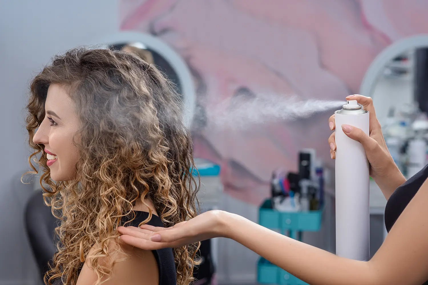 Professional application of heat protectant spray before hot tool styling at Melenas