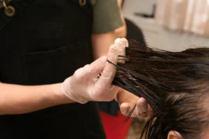 Corrección profesional de color capilar complejo por un estilista en Melenas Peluquería