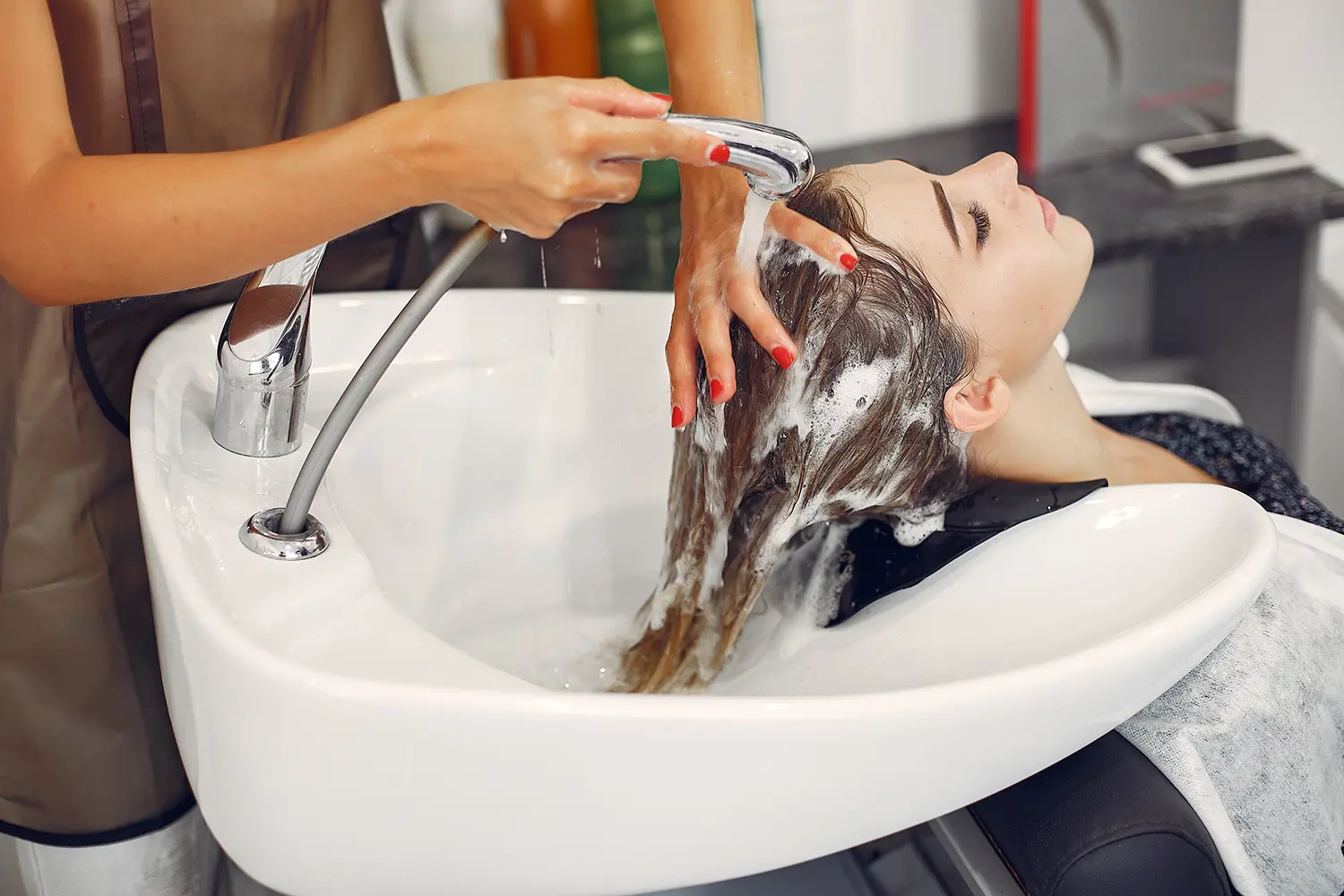 Técnica profesional de lavado de cabello y cuidado capilar en el salón Melenas